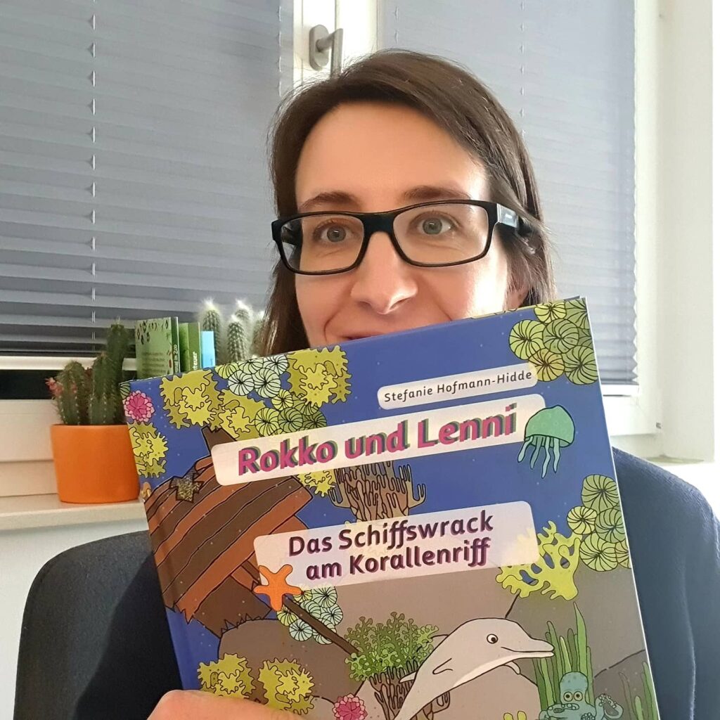 Stefanie Hofmann-Hidde hält das erste Exemplar von "Rokko und Lenni - Das Schiffswrack am Korallenriff" in der Hand